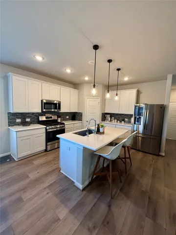 a open kitchen with stainless steel appliances kitchen island granite countertop a stove a sink a refrigerator and a microwave