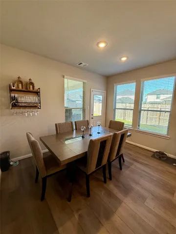 a view of a dining room with furniture a livingroom and wooden floor