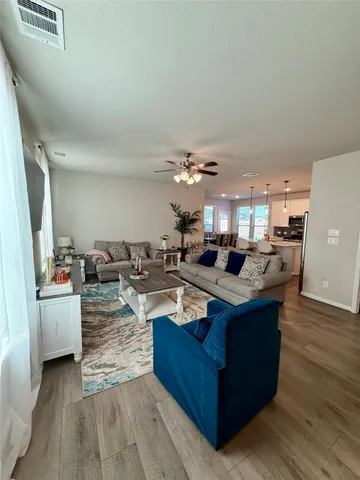 a living room with furniture and a view of kitchen