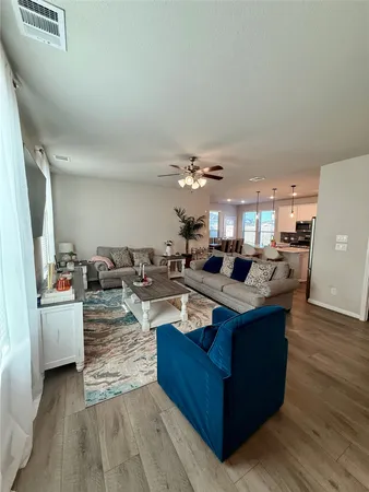 a living room with furniture and a large mirror with wooden floor