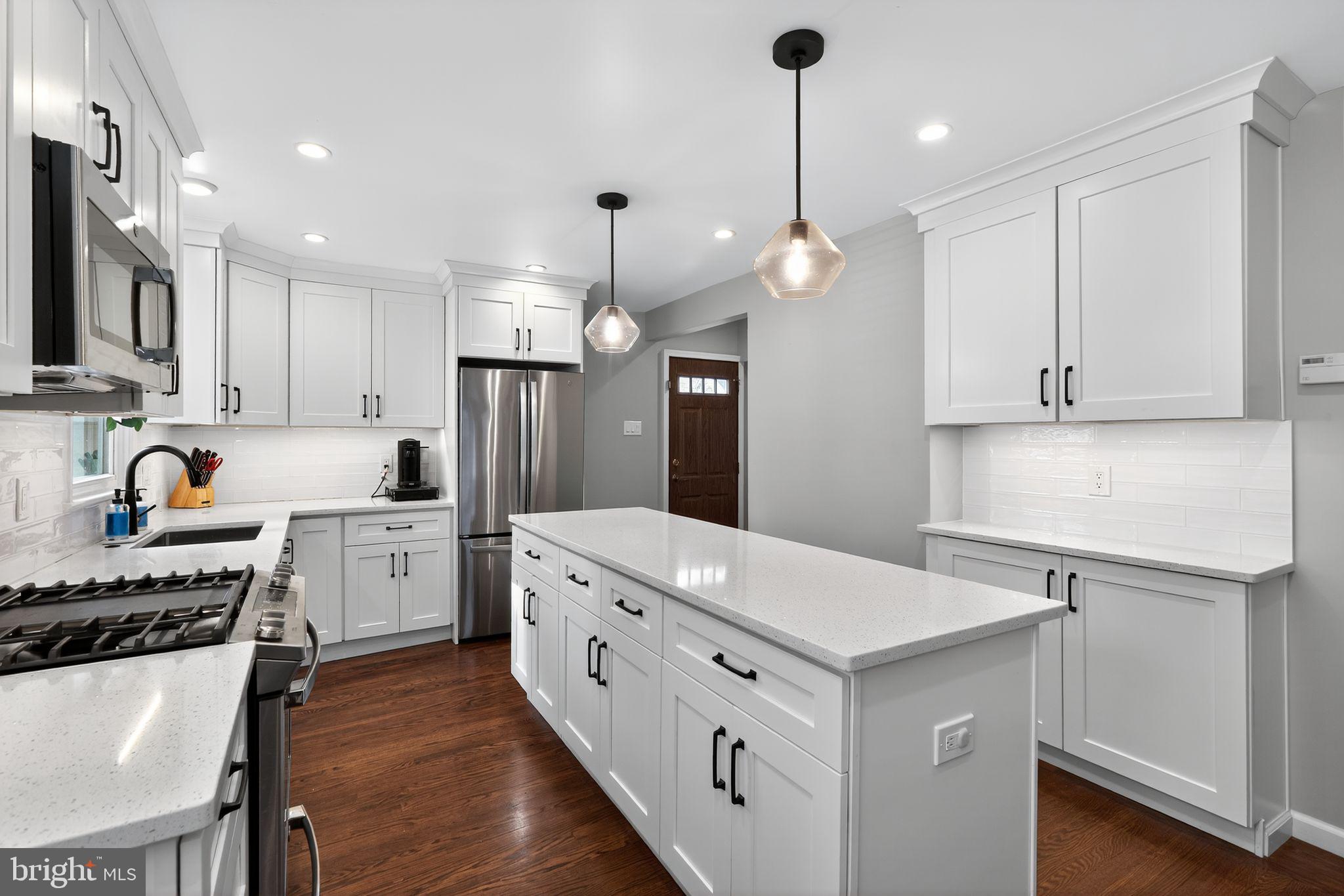 214 Lynbrooke Road Springfield, PA 19064 - Photo 11 of 42 a kitchen that has a lot of cabinets in it and wooden floors