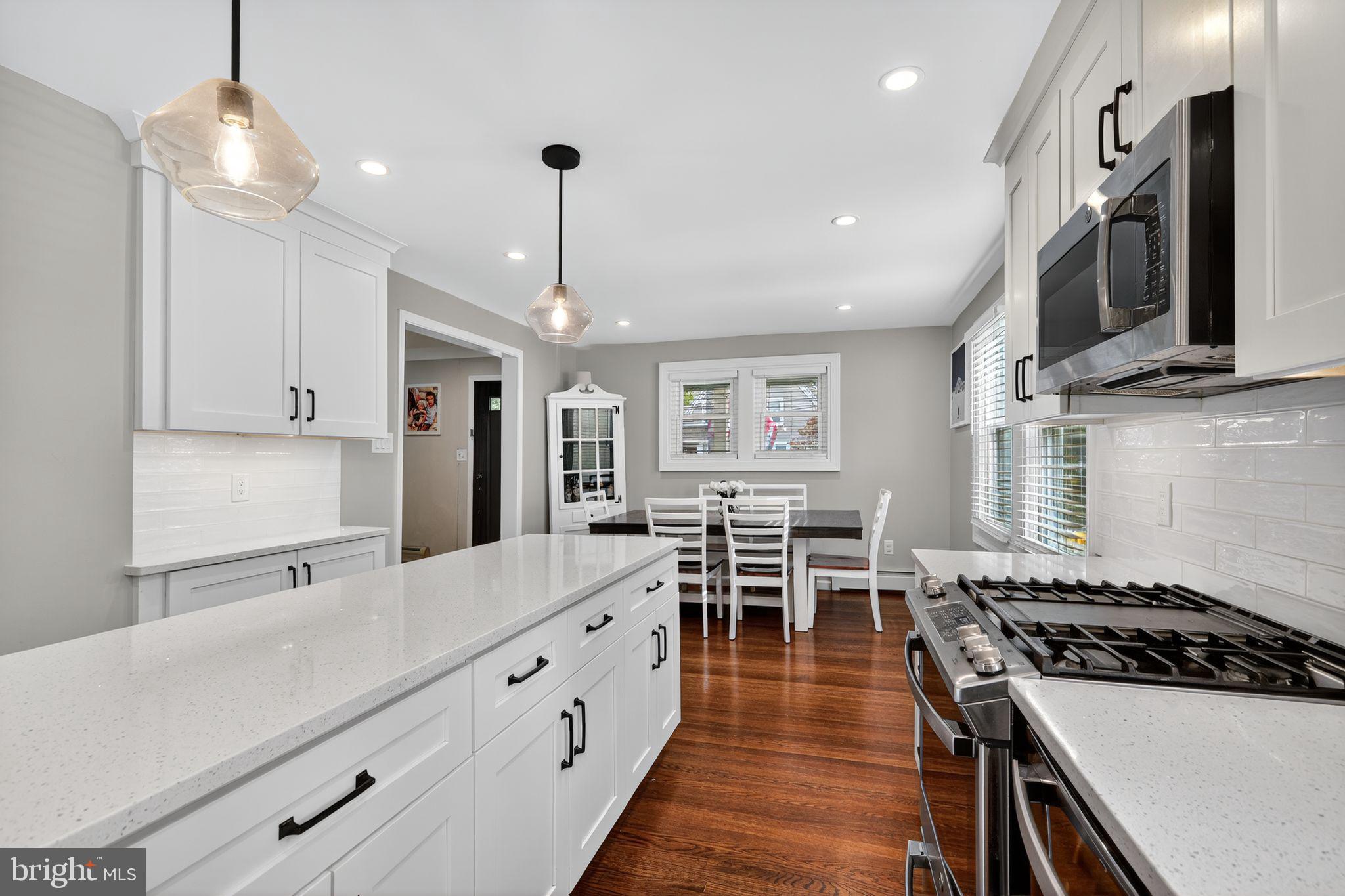 214 Lynbrooke Road Springfield, PA 19064 - Photo 15 of 42 a open kitchen with stainless steel appliances granite countertop a stove and a wooden floors