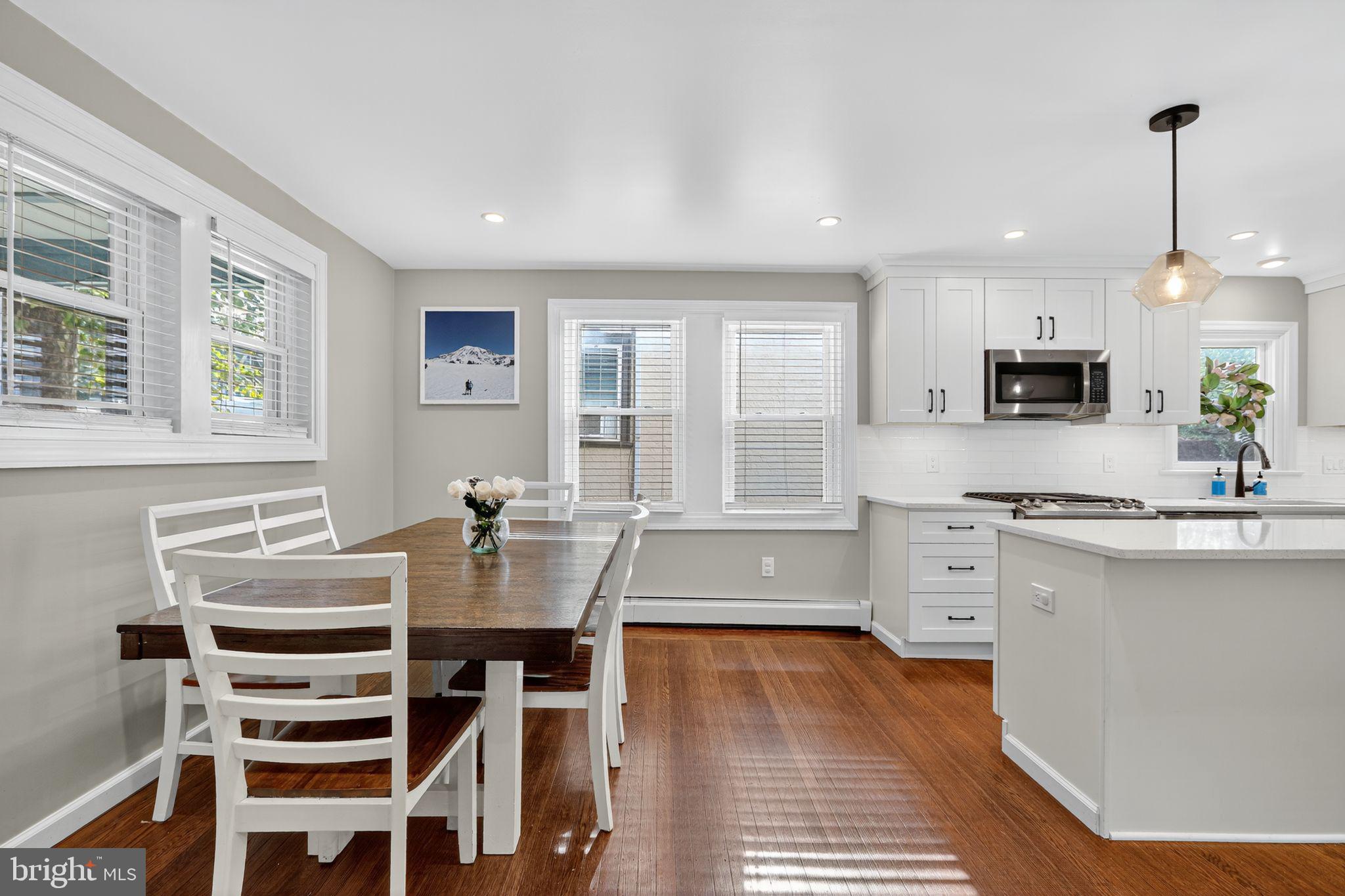214 Lynbrooke Road Springfield, PA 19064 - Photo 16 of 42 a kitchen with stainless steel appliances kitchen island granite countertop a stove a sink dishwasher a dining table and chairs with wooden floor
