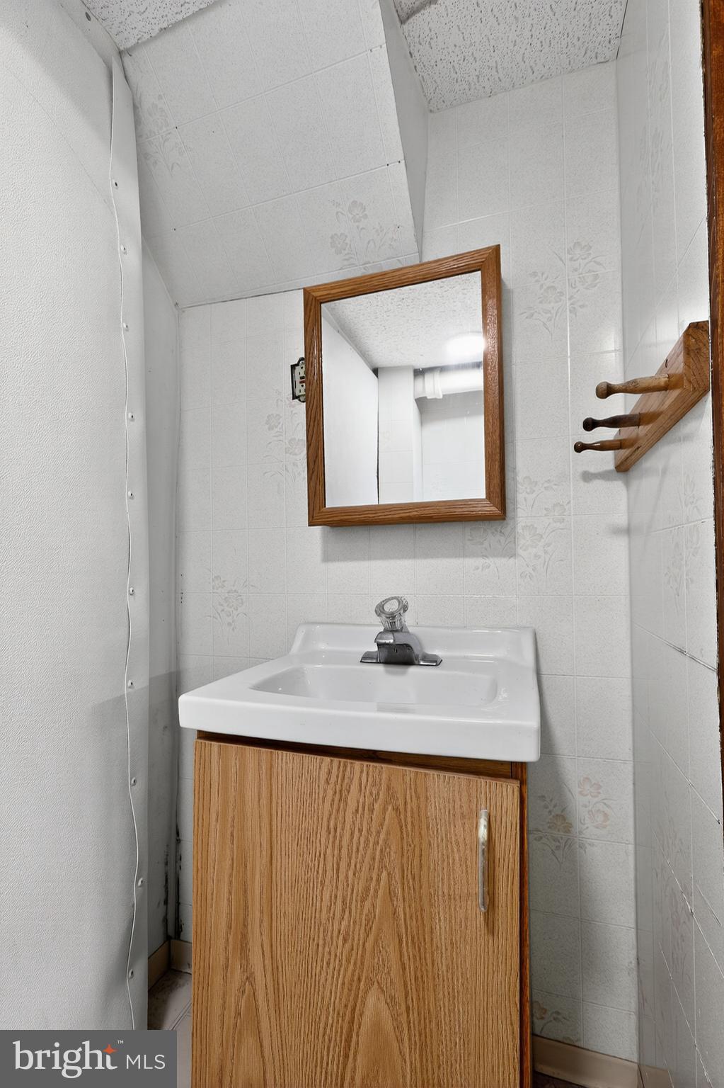 214 Lynbrooke Road Springfield, PA 19064 - Photo 33 of 42 a bathroom with a granite countertop sink a mirror and vanity