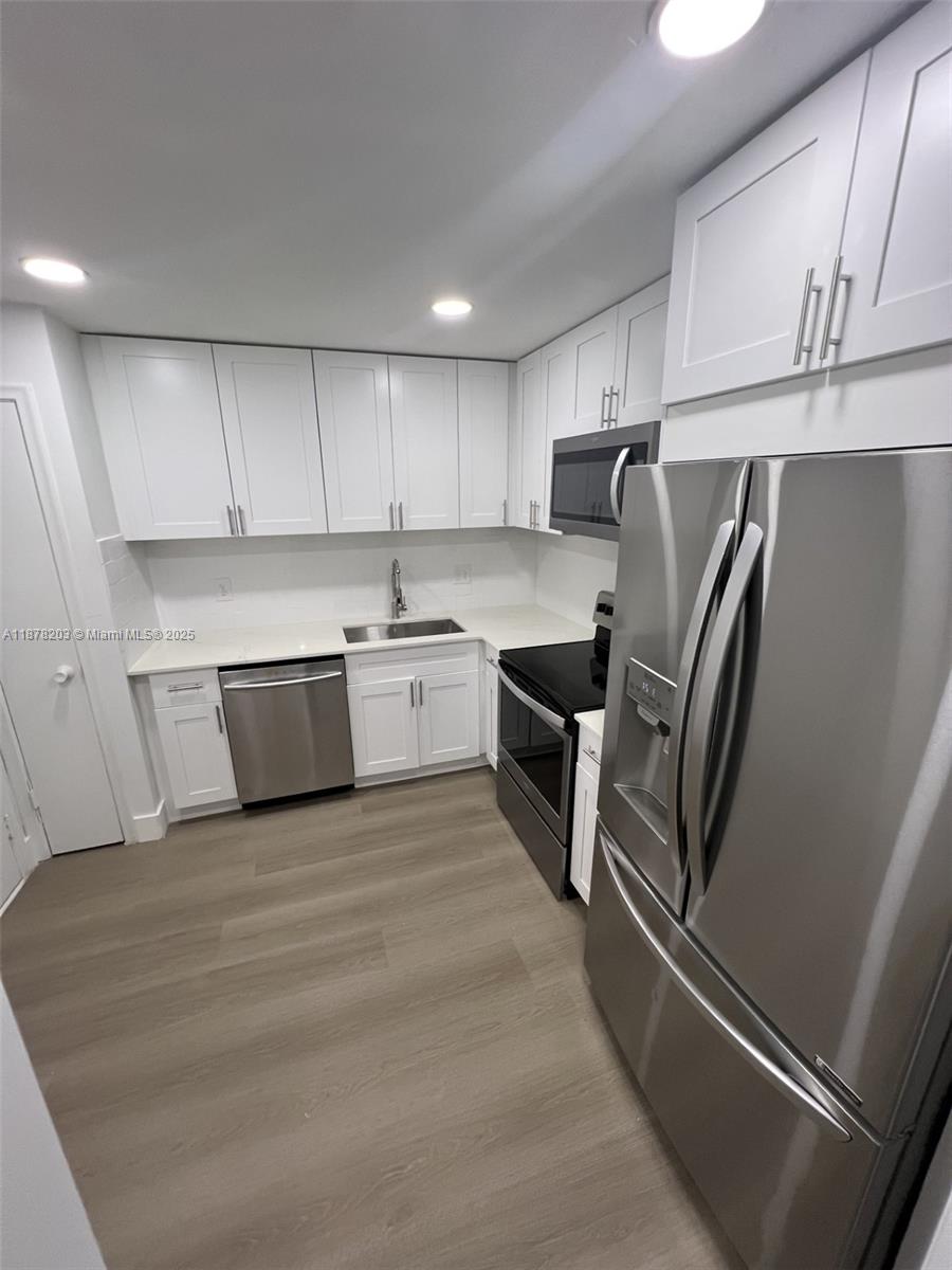 22605 Southwest 66th Avenue, Unit 403 Boca Raton, FL 33428 - Photo 1 of 10 a kitchen with stainless steel appliances granite countertop a refrigerator sink and cabinets