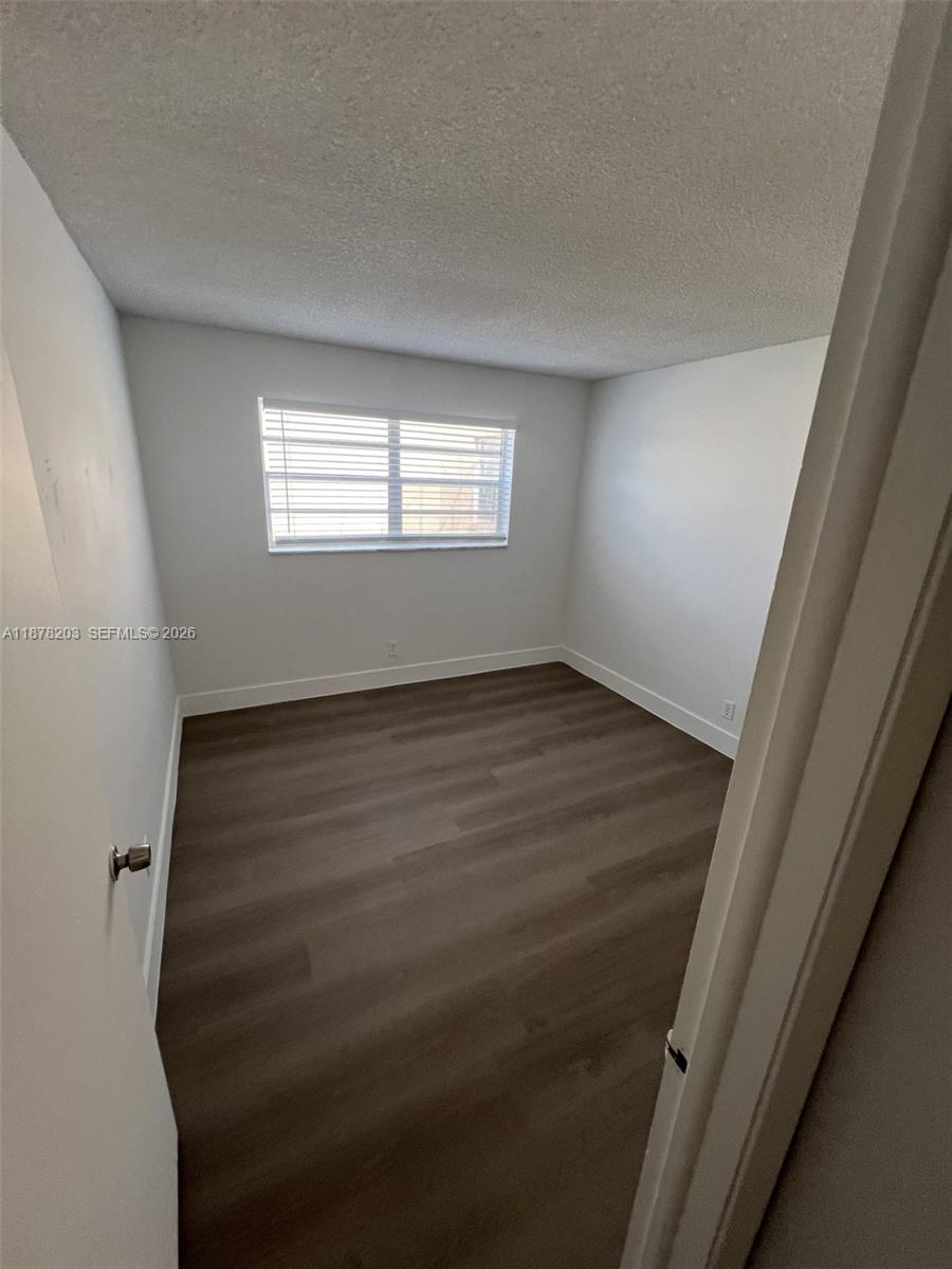 22605 Southwest 66th Avenue, Unit 403 Boca Raton, FL 33428 - Photo 14 of 20 wooden floor in an empty room with a window