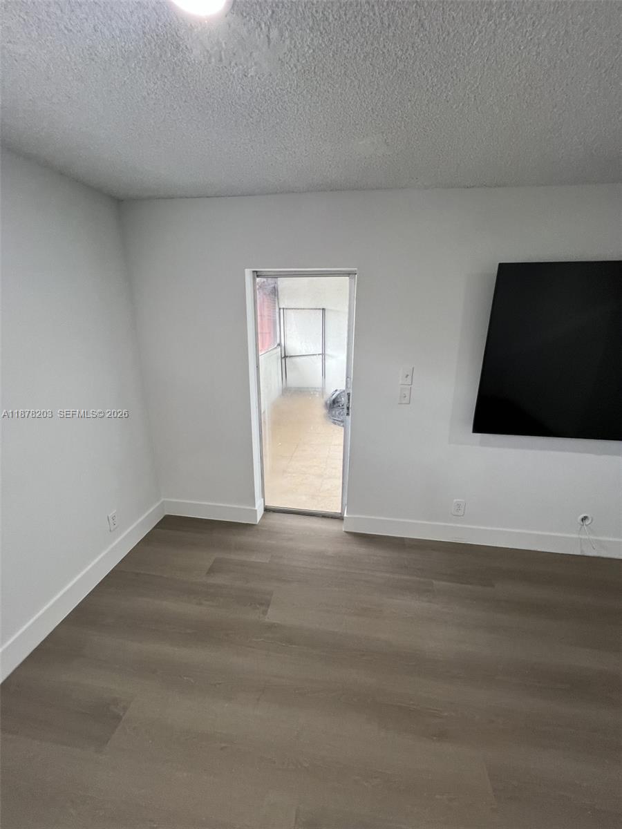 22605 Southwest 66th Avenue, Unit 403 Boca Raton, FL 33428 - Photo 19 of 20 a view of an empty room with wooden floor and a window