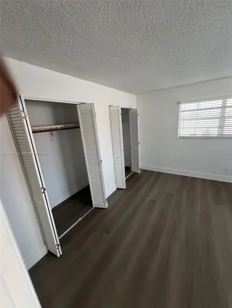 an empty room with wooden floor and entrance