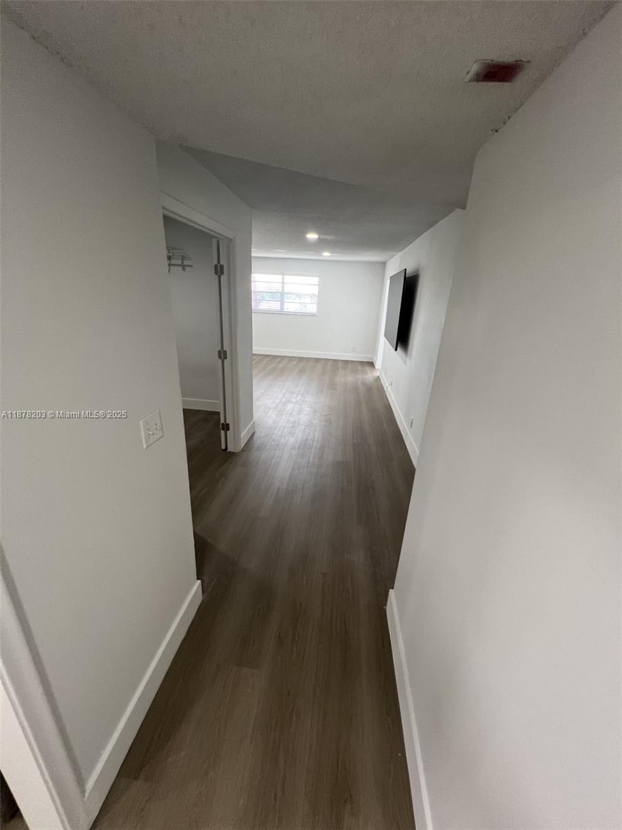 22605 Southwest 66th Avenue, Unit 403 Boca Raton, FL 33428 - Photo 2 of 10 a view of a hallway with wooden floor and staircase