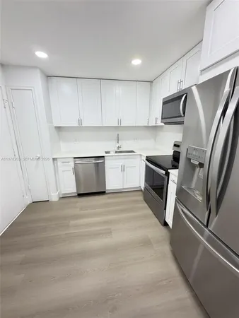 a kitchen with stainless steel appliances granite countertop a refrigerator sink and stove