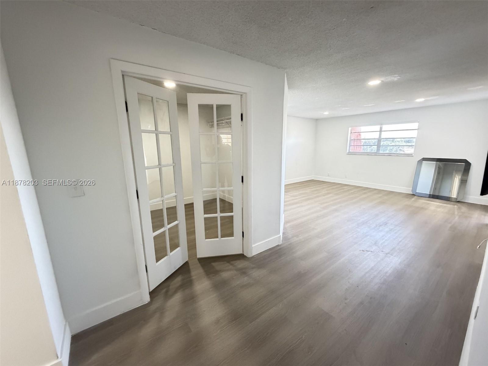 22605 Southwest 66th Avenue, Unit 403 Boca Raton, FL 33428 - Photo 4 of 20 an empty room with wooden floor and windows
