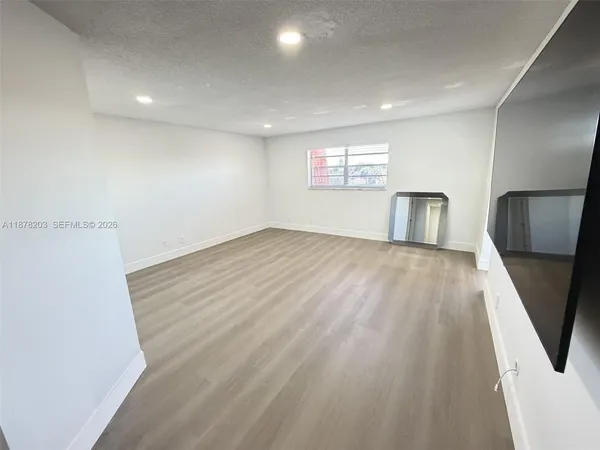 an empty room with wooden floor and a window