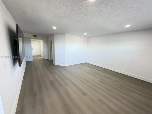 an empty room with wooden floor and a window