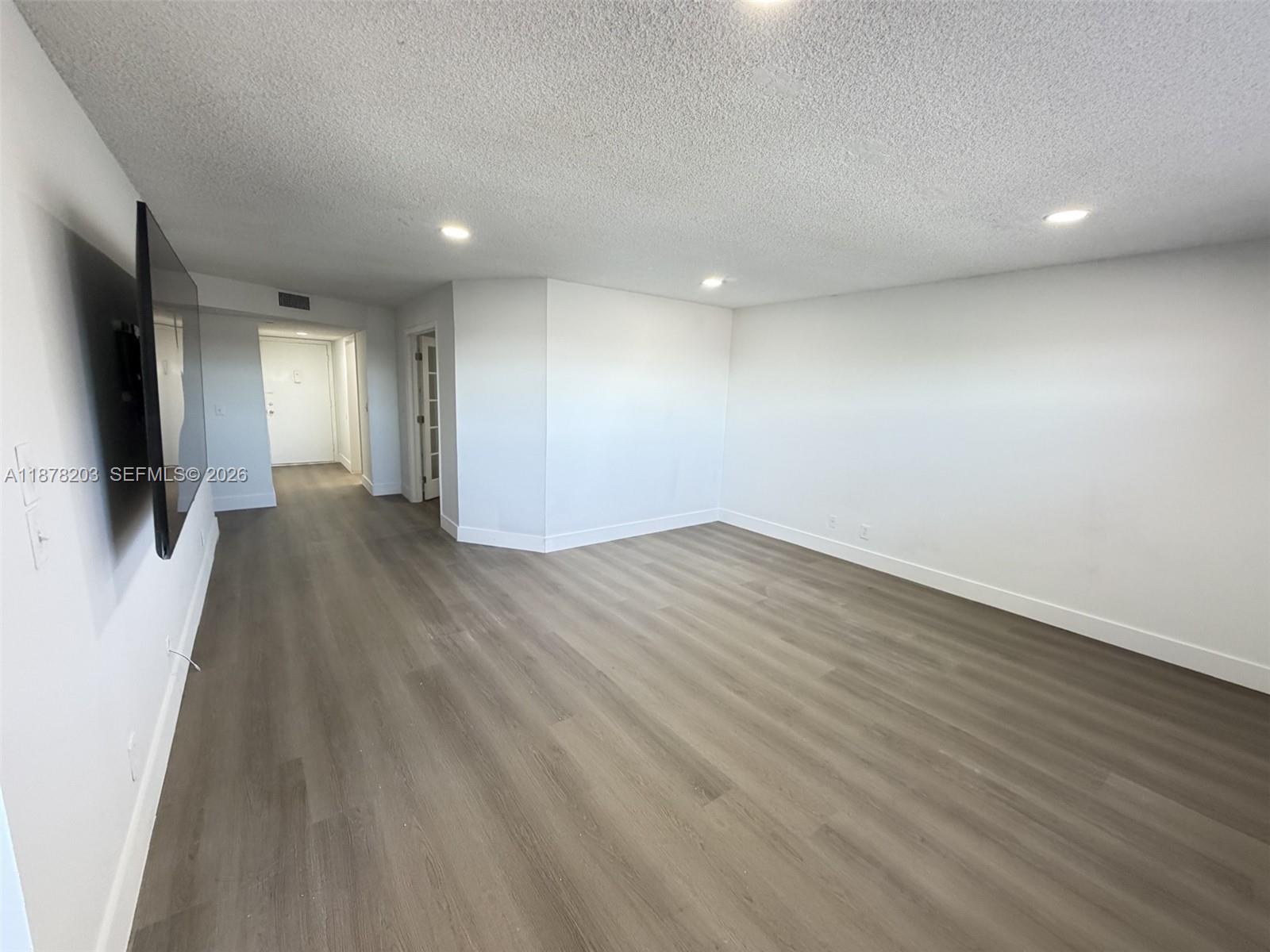 22605 Southwest 66th Avenue, Unit 403 Boca Raton, FL 33428 - Photo 9 of 20 an empty room with wooden floor and a window