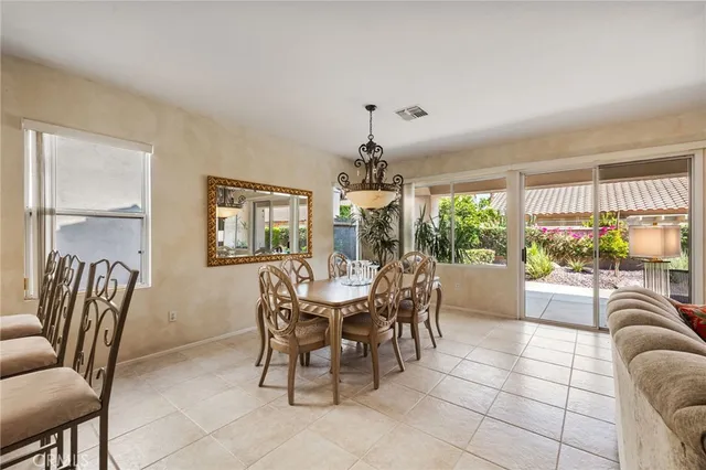 a dining room with furniture a large window and potted plants