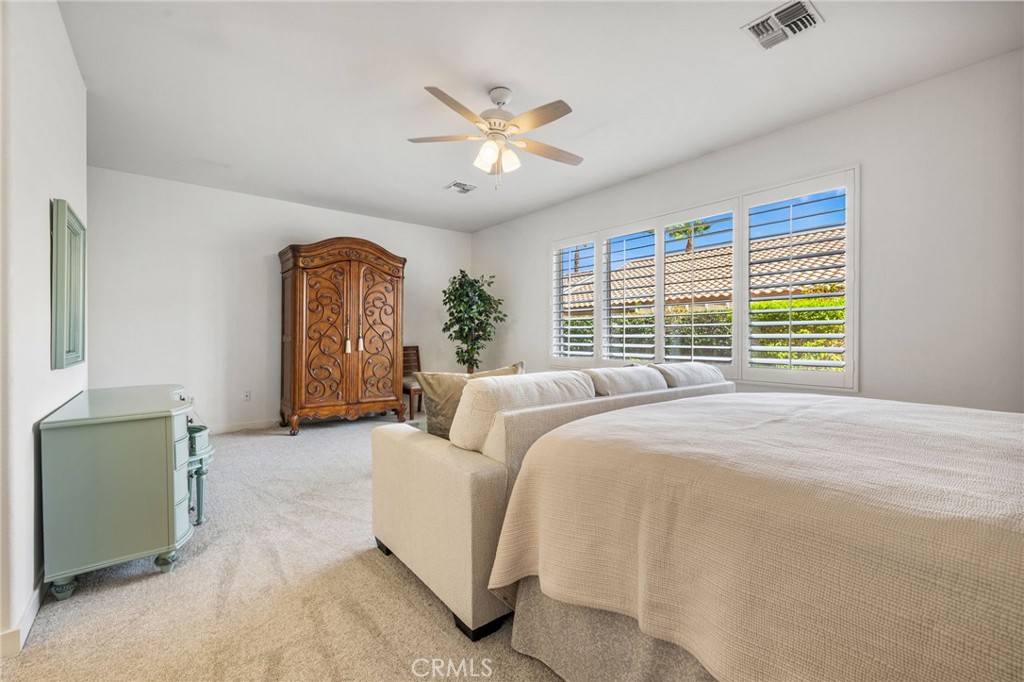 78770 Golden Reed Drive Palm Desert, CA 92211 - Photo 30 of 36 a bed room with a bed and a chandelier