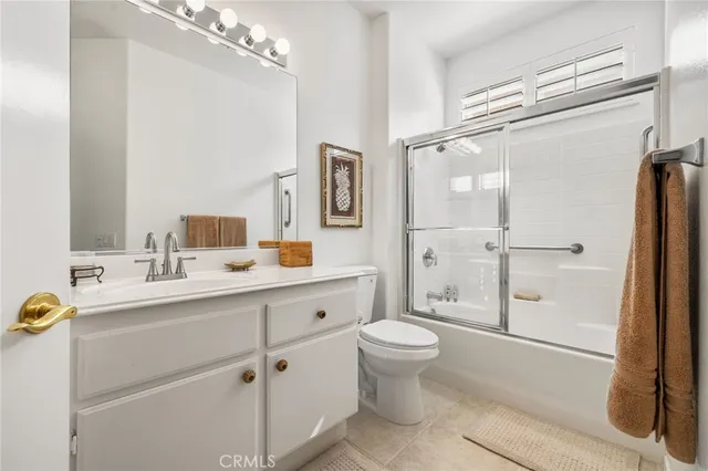 a bathroom with a granite countertop sink toilet a mirror and shower