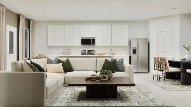 a living room with furniture and a refrigerator