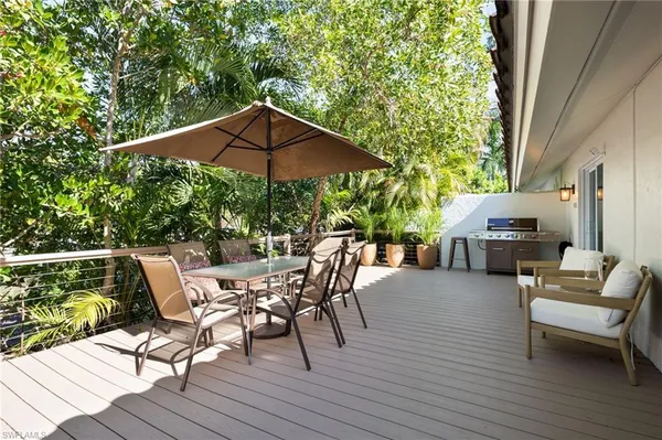 a patio with wooden floor and umbrella