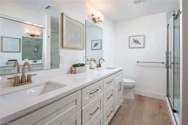 a bathroom with a sink a toilet a shower and a mirror