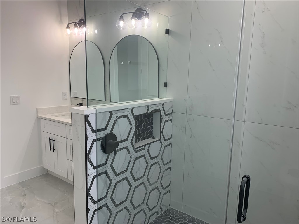 526 Raintree Street East Lehigh Acres, FL 33974 - Photo 14 of 21 a bathroom with a mirror and a shower