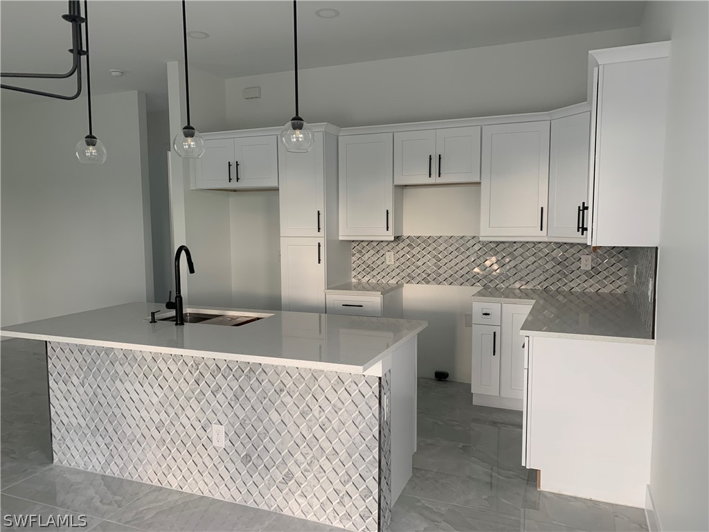 526 Raintree Street East Lehigh Acres, FL 33974 - Photo 7 of 21 a kitchen with a sink a refrigerator and cabinets