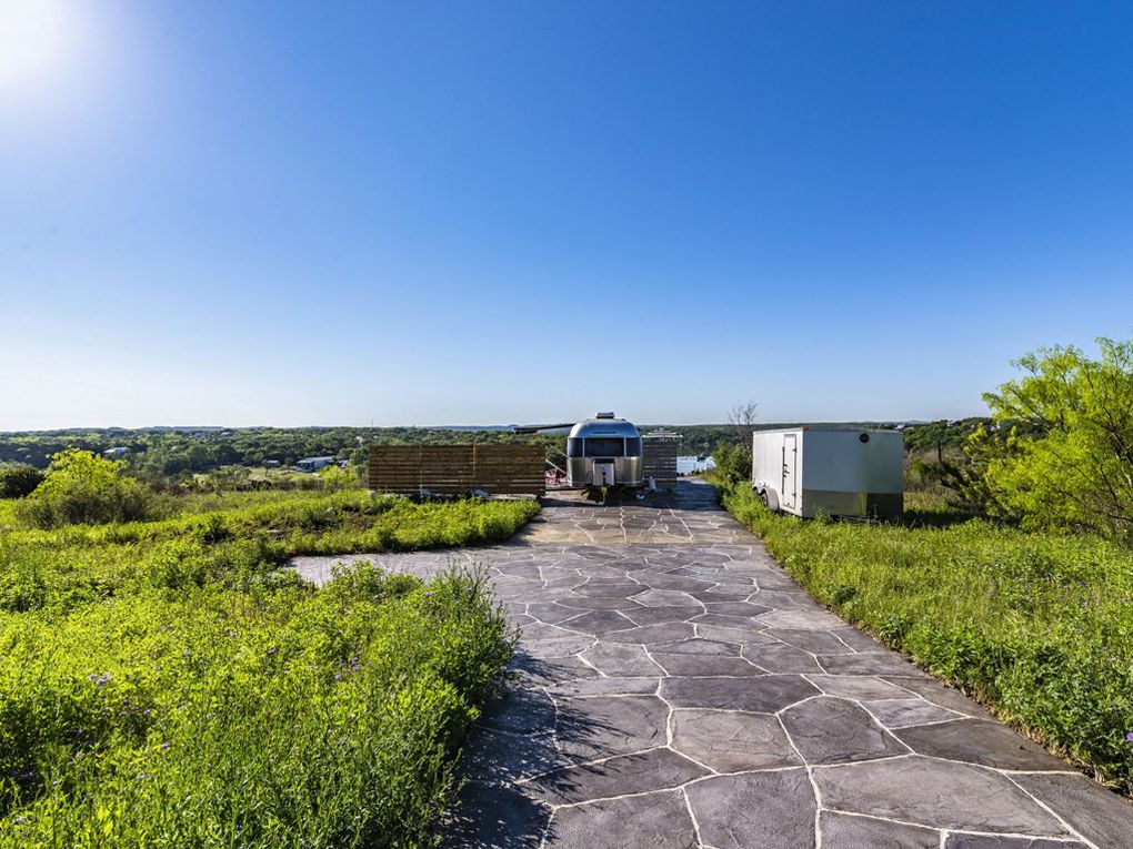 An extensive stone-paved driveway leads toward sweeping views of the surrounding countryside.