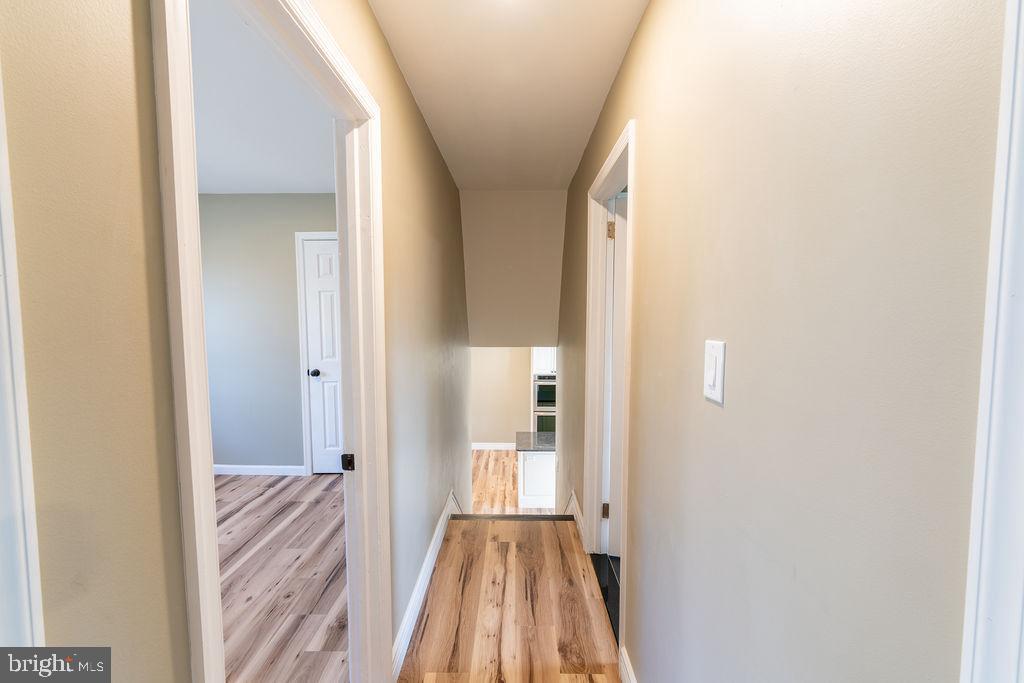 706 Center Street Kennett Square, PA 19348 - Photo 19 of 39 a view of a hallway with wooden floor and a bathroom