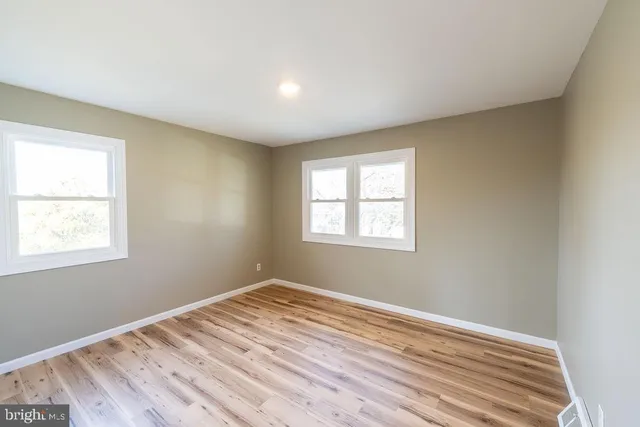 a view of a room with wooden floor and windows