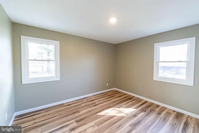 a view of a room with wooden floor and windows