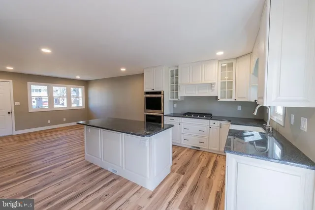 a kitchen with granite countertop white cabinets and white appliances
