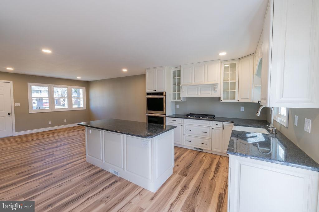 706 Center Street Kennett Square, PA 19348 - Photo 5 of 39 a kitchen with granite countertop white cabinets and white appliances