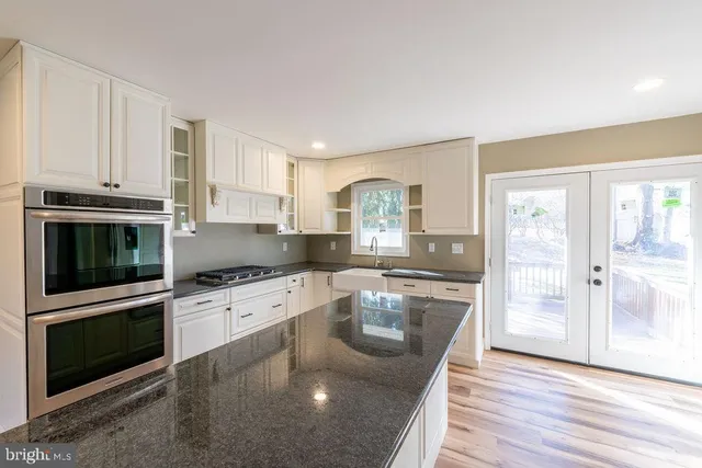 a kitchen with granite countertop a stove top oven and sink