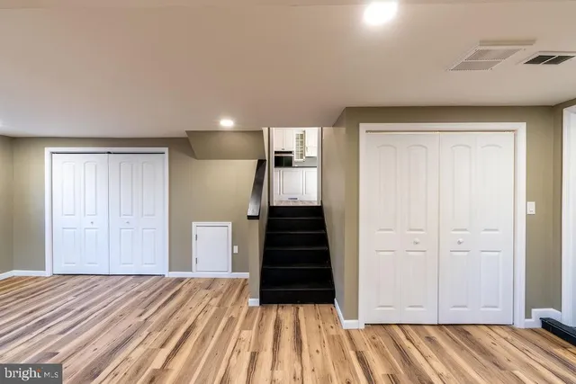 a view of a bedroom with wooden floor and stairs
