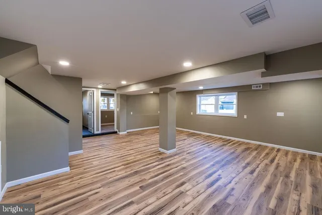 a view of empty room with wooden floor