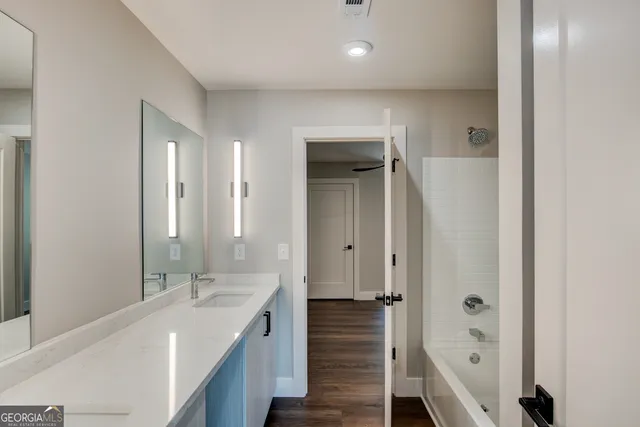 a bathroom with a double vanity sink a mirror and a bathtub