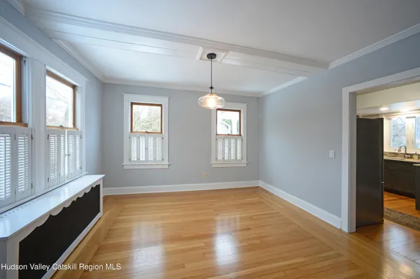 a view of an empty room with glass door and wooden floor