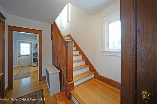 a view of a hallway with wooden floor and staircase
