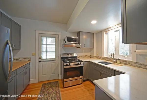 a kitchen with granite countertop a sink stove and refrigerator