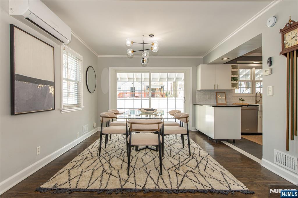 1169 Broad Street Bloomfield, NJ 07003 - Photo 12 of 47 a dining room with wooden floor a chandelier a wooden table and chairs