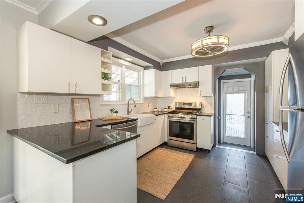 1169 Broad Street Bloomfield, NJ 07003 - Photo 19 of 47 a kitchen with stainless steel appliances granite countertop a sink and stove