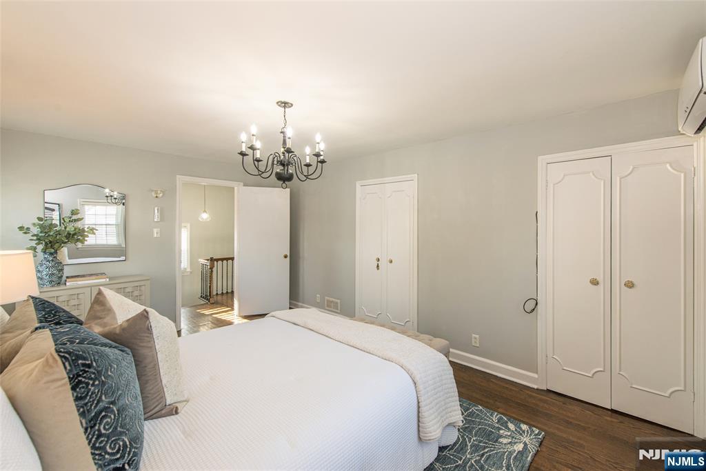 1169 Broad Street Bloomfield, NJ 07003 - Photo 28 of 47 a spacious bedroom with a bed and chandelier