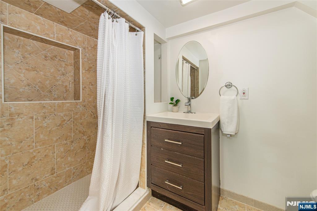 1169 Broad Street Bloomfield, NJ 07003 - Photo 41 of 47 a bathroom with a sink vanity and mirror