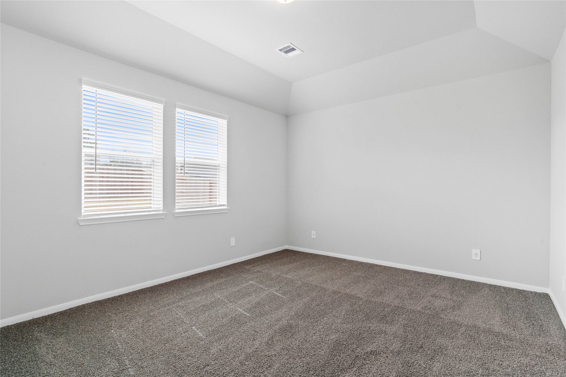 19657 Montgomery Rdg Way Montgomery, TX 77316 - Photo 27 of 49 The primary bedroom provides a peaceful escape with a bright, neutral palette, sloped ceilings, large windows (fitted with blinds), and plush carpet flooring, creating a calm and restorative atmosphere to end your day.
