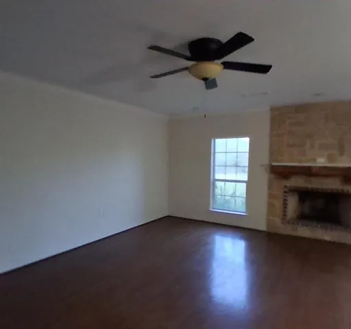 an empty room with a fireplace and windows