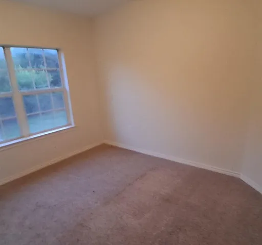 a view of a small space with wooden floor and a window