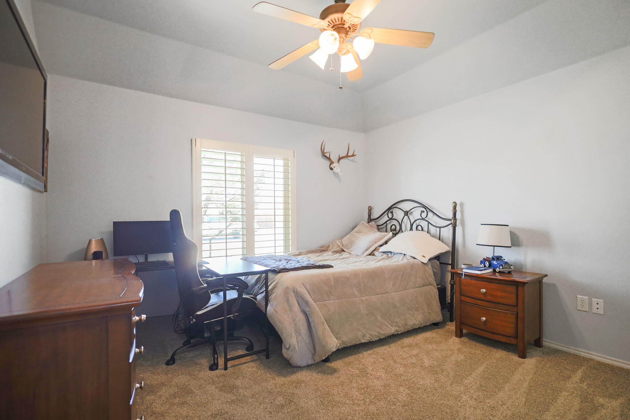 6005 93rd Street Lubbock, TX 79424 - Photo 19 of 31 a bedroom with a bed and a chandelier