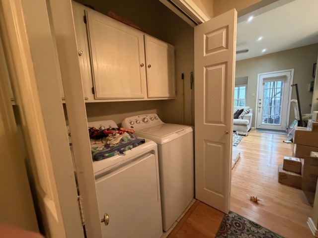 3809 Spicewood Springs Road, Unit 119 Austin, TX 78759 - Photo 11 of 14 Convenient laundry area with built-in cabinetry, located within a room featuring hardwood floors and a white door with glass panels