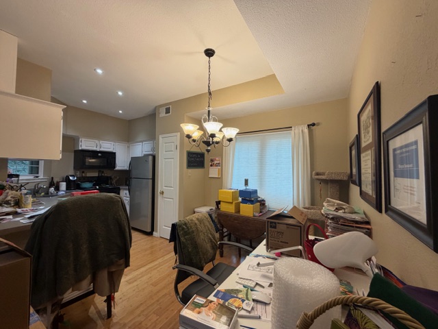 3809 Spicewood Springs Road, Unit 119 Austin, TX 78759 - Photo 3 of 14 The open-concept living area features a kitchen with white cabinetry and stainless steel appliances, hardwood flooring, and a dining space with a ceiling light fixture