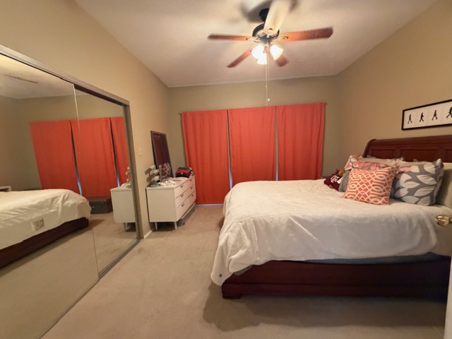 3809 Spicewood Springs Road, Unit 119 Austin, TX 78759 - Photo 8 of 14 Bedroom featuring a ceiling fan with light, a mirrored closet door, and carpeted flooring